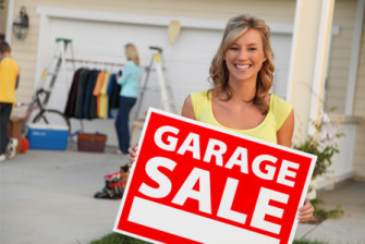 woman-holding-garage-sale-sign-horiz